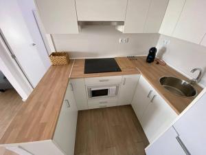 a small kitchen with white cabinets and a sink at Apartamento Paradis con encanto y vistas al mar in Vinaròs