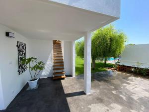 a white house with a staircase and a potted plant at Apartamento Paradis con encanto y vistas al mar in Vinaròs