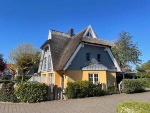una casa amarilla y gris con techo gris en Mine Heimat _ Dat Roeverhus_, en Zingst