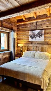 sypialnia z drewnianą ścianą i łóżkiem w obiekcie Chalet Les Cocales Résidence Séjour et nuitées B&B - Appartement Pin Cembro w mieście Bessans