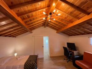 a bedroom with wooden ceilings and a bed and a desk at Casa do Avô Fernando in Agualva