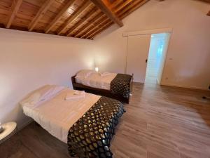 a room with two beds in a room with wooden floors at Casa do Avô Fernando in Agualva