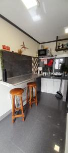 a kitchen with two wooden stools in front of a counter at Los Amantes de la naturaleza. in Salão