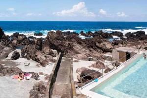 a resort with a swimming pool and the beach at Casa do Avô Fernando in Agualva