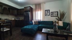 sala de estar con sofá verde y mesa en Oikos Selinolithos en Alaminos