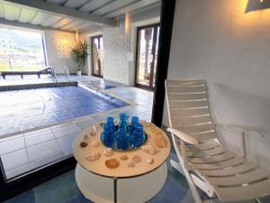 ein Tisch mit blauer Brille neben einem Pool in der Unterkunft Villa Edelweiss - 3 to 6 Guests - private use of indoor pool, sauna and garden terrace in Abtenau