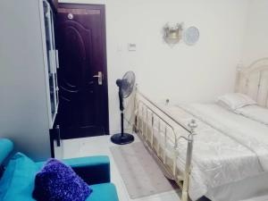 - une chambre avec un lit et un ventilateur à côté d'une porte dans l'établissement serene luxury master bedroom, à Charjah
