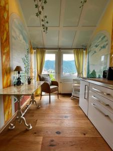 a kitchen with a table and a chair and windows at PARK VILLA zentral am Mittelrhein in Boppard