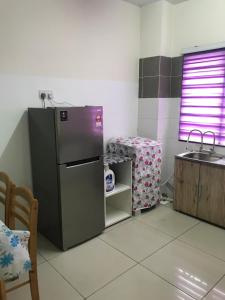 a kitchen with a stainless steel refrigerator and a table at AZ HomeStay Bandar Puncak Alam in Bandar Puncak Alam