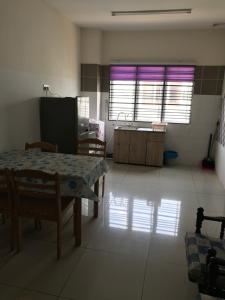 a room with a table and a kitchen with windows at AZ HomeStay Bandar Puncak Alam in Bandar Puncak Alam