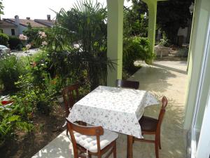 einen Tisch und Stühle auf der Veranda eines Hauses in der Unterkunft Apartman DUBRAVKA in Crikvenica