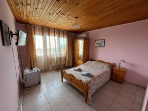 1 dormitorio con cama y techo de madera en Guest House Paskal, en Balchik