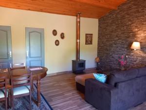 een woonkamer met een bank, een tafel en een open haard bij O Ninho do Rei in Vila de Rei