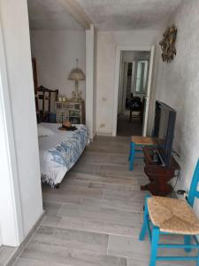 a bedroom with a bed and a tv and a table at Magi - Violetta in Ponza