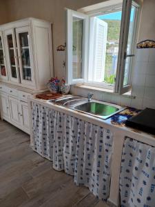 uma cozinha com um lavatório e uma janela em Magi - Violetta em Ponza