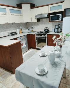 una cocina con una mesa con tazas y platillos. en Apartament nad Nidą, en Sobków