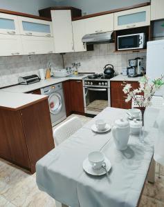a kitchen with a table with cups and saucers on it at Apartament nad Nidą in Sobków +28 photos