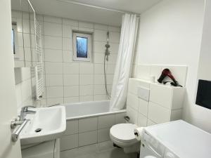 een witte badkamer met een toilet en een wastafel bij LUXOMES: Design Apartment - private Parking - 4 People in Ingolstadt