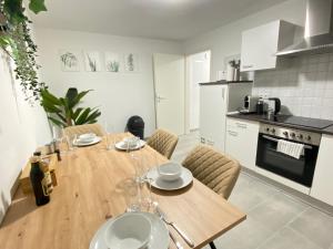 een keuken en eetkamer met een houten tafel en stoelen bij LUXOMES: Design Apartment - private Parking - 4 People in Ingolstadt