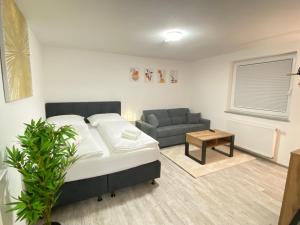 een woonkamer met een bed en een bank bij LUXOMES: Design Apartment - private Parking - 4 People in Ingolstadt