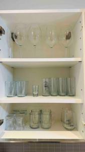 un montón de vasos sentados en estanterías en una cocina en Havuz&Peyzaj Manzaralı LUX 2+1, en Konak