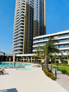 a resort with a swimming pool and a tall building at Havuz&Peyzaj Manzaralı LUX 2+1 in Konak
