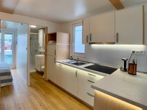 - une cuisine avec des placards blancs et un évier dans l'établissement BellaVista HouseBoat Apartment Portorose, à Portorož