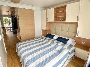 een slaapkamer met een blauw en wit gestreept bed bij BellaVista HouseBoat Apartment Portorose in Portorož