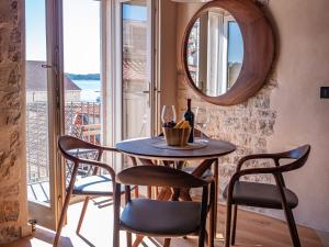 una sala da pranzo con tavolo, sedie e specchio di Villa Porta Maestra a Hvar