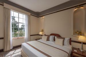Ένα ή περισσότερα κρεβάτια σε δωμάτιο στο The Grand Hotel - Heritage Grand