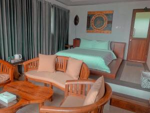a bedroom with a bed and a table and chairs at De Pointé Resort & Resto in Campaka