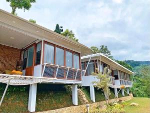 a large house with a porch and a balcony at De Pointé Resort & Resto in Campaka