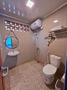 a bathroom with a toilet and a sink at De Pointé Resort & Resto in Campaka