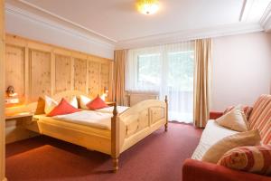 a bedroom with a bed and a desk and a couch at Landhaus Angelika in Gaschurn