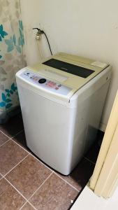 uma máquina de lavar roupa sentada no chão num quarto em Vista Alam Roomstay Homestay em Shah Alam