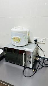 a slow cooker sitting on top of a toaster oven at Vista Alam Roomstay Homestay in Shah Alam