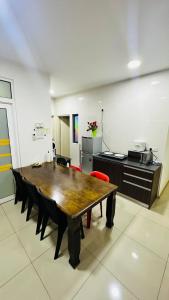 a dining room with a table and a kitchen at Vista Alam Roomstay Homestay in Shah Alam
