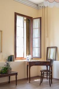 Farra di SoligoにあるFiori&vigne di Cecilia Marconの木製テーブルと窓2つが備わる客室です。