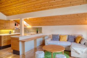 a kitchen and living room with a couch and a table at Ruhige Ferienwohnungen in Partenkirchen 1 in Garmisch-Partenkirchen