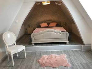 a bedroom with a bed and a chair in a attic at Maison avec spa - Côte d'Opale in Lottinghen