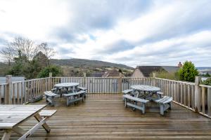 a deck with benches and picnic tables on it at The New Lodge in Pontardawe