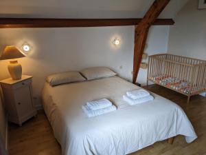 1 dormitorio con 1 cama blanca y 2 toallas en Clos du Château - Large House with Private Pool and Valley View, 