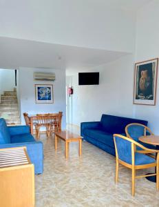 a living room with a blue couch and a table at Eliofos Elegant Maisonettes in Polis Chrysochous