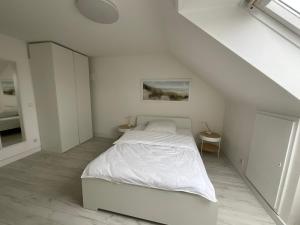 a white bedroom with a bed and a staircase at City Flat gegenüber Kurhaus, Zentrum Freudenstadt in Freudenstadt