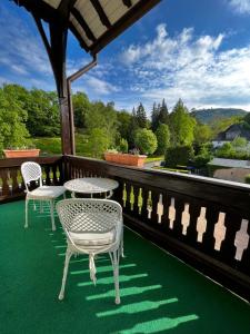 a patio with two tables and chairs on a balcony at PARK VILLA zentral am Mittelrhein Zimmer&Apartments Self check in Aparthotel in Boppard