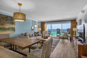 a living room with a table and a couch and a television at Beach House 603D- Rest Ashore in Destin