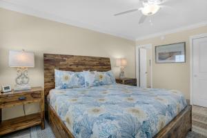 a bedroom with a large bed with a wooden headboard at Beach House 603D- Rest Ashore in Destin +45 photos
