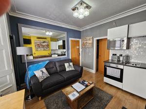 a living room with a couch and a kitchen at The Hyding Place on George Street in Whitby