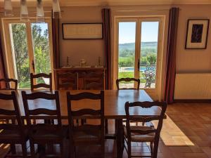 comedor con mesa, sillas y ventanas en Clos du Château - Large House with Private Pool and Valley View, 