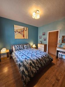 a bedroom with a bed and a blue wall at The Hyding Place on George Street in Whitby